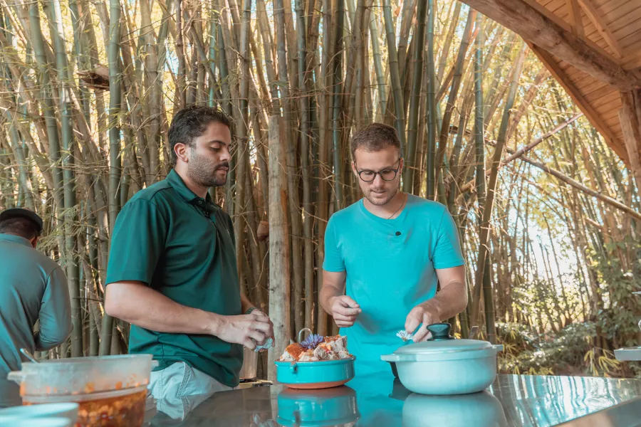 Two people preparing pernil, a slow cooked pork dish at Finca la Zafra in Gurabo, Puerto Rico 