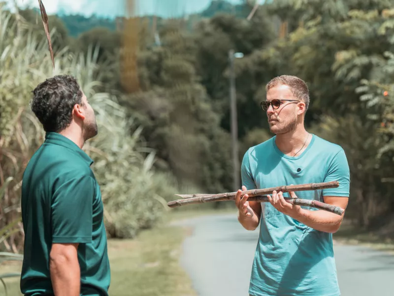 Two people holding sugarcane at Finca la Zafra in Gurabo, Puerto Rico.