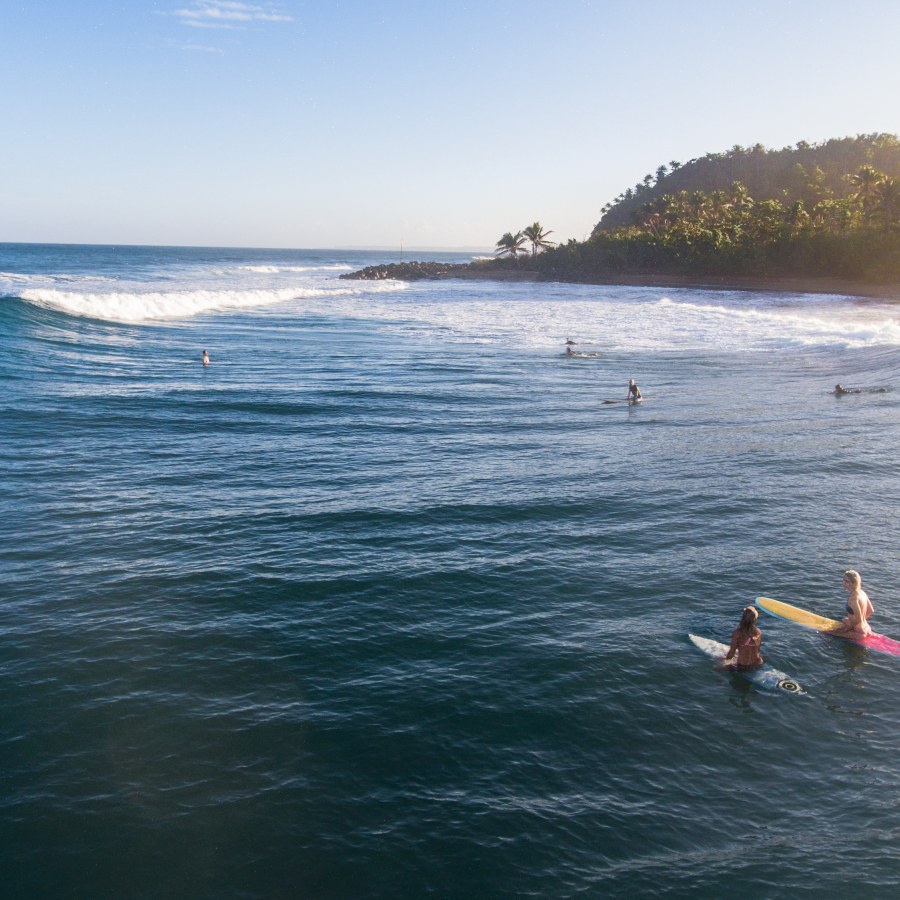 Surfers catching waves at Domes Beach in Rincón, Puerto Rico