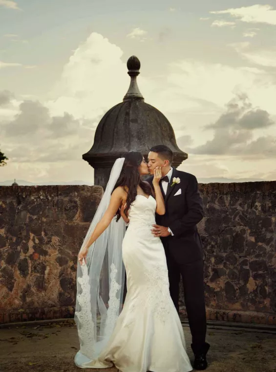 A bride and groom kiss in front of a historic garita in Old San Juan. Photo by Noel Del Pilar.